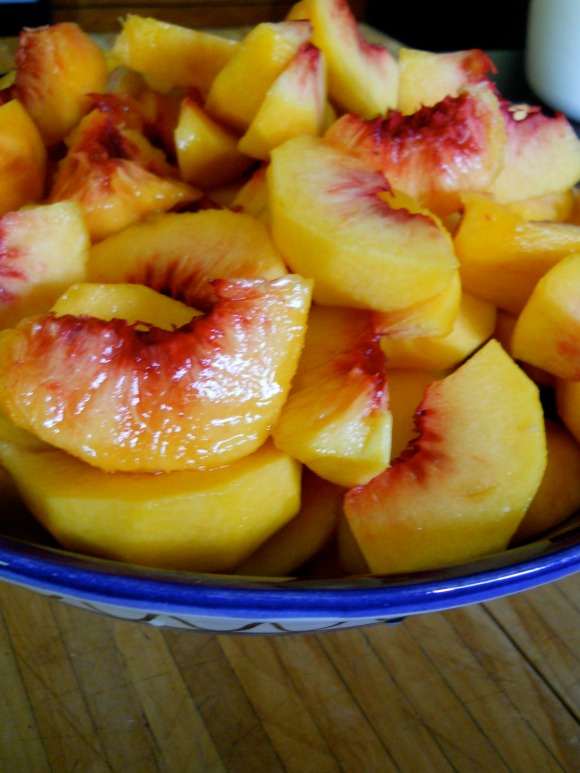 blue bowl of fresh slices of peaches
